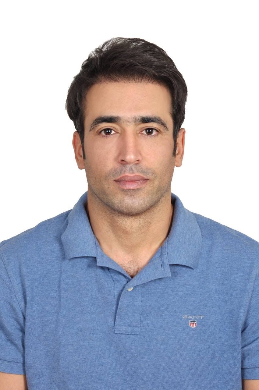 Man wearing a blue polo shirt against a plain white background.